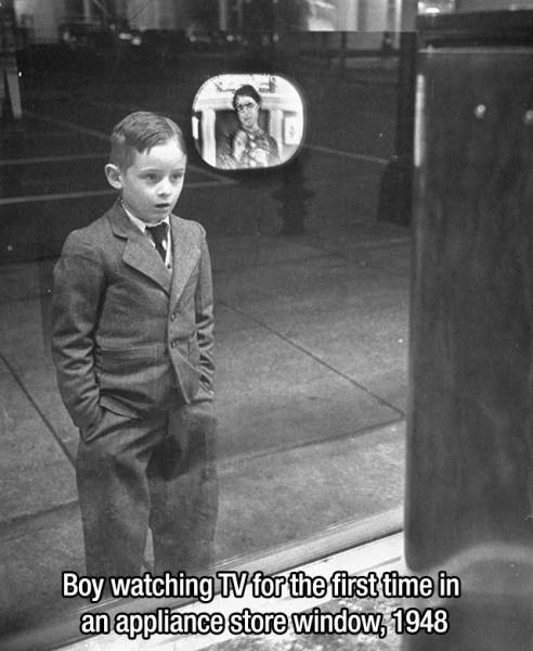 Boy watching TV for the first time in an appliance store window, 1948